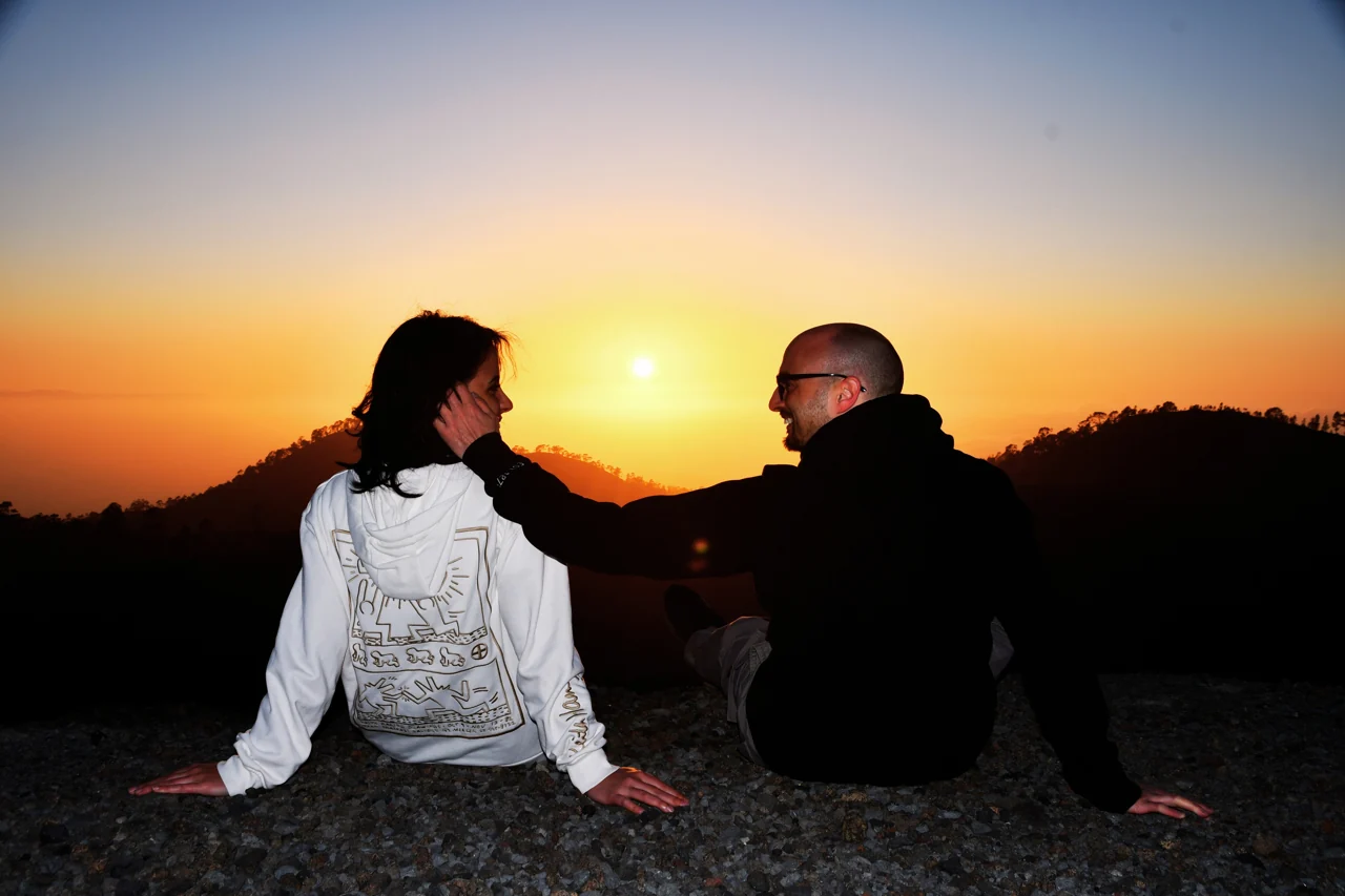 Ivan and Valentina facing each other against an orange sunset