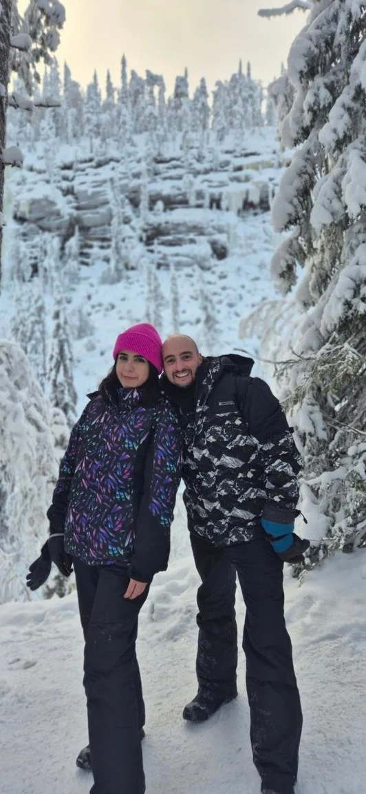 Valentina and Ivan standing together in a snow-covered forest